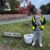 Person in yellow vest with litter picker stands by CASSIA GREEN sign and bag of rubbish.